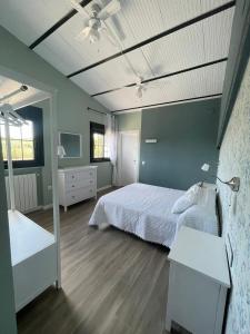 a bedroom with a white bed and a white dresser at Caserío de Charca Cuca in Úbeda