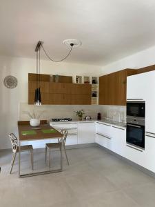 a kitchen with white cabinets and a table and chairs at LA MOTOCICLETTA in Bagnone