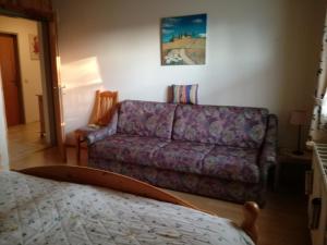 sala de estar con sofá púrpura y cama en Bergblick, en Sirnitz