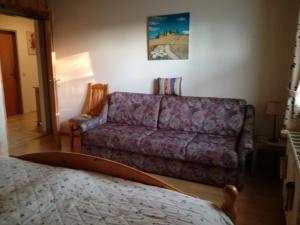 a living room with a purple couch and a bed at Bergblick in Sirnitz