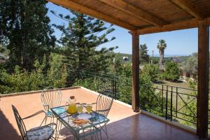 a patio with a table and chairs on a deck at Villa Orion - Peaceful Retreat Home West of Chania in Kipárissos