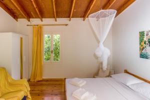 a bedroom with a white bed and a window at Villa Orion - Peaceful Retreat Home West of Chania in Kipárissos