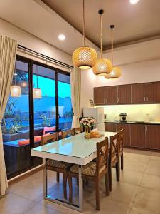 a kitchen and dining room with a table and chairs at THE OASIS 4BR Private Pool Pet-Friendly Villa Vimala Hills in Gadok 1