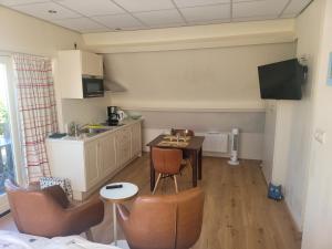 a kitchen with a table and chairs in a room at Pension Canberra in Bergen aan Zee