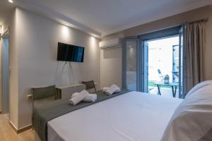 a hotel room with a large bed with towels on it at OLYMPIA ROOMS in Myrina