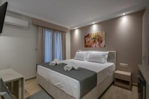 a bedroom with a bed with towel animals on it at OLYMPIA ROOMS in Myrina