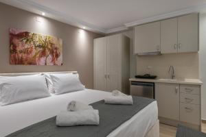 a bedroom with a large white bed with towels on it at OLYMPIA ROOMS in Myrina