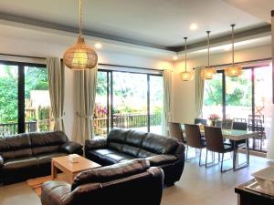 a living room with leather couches and a dining room at THE OASIS 4BR Private Pool Pet-Friendly Villa Vimala Hills in Gadok 1