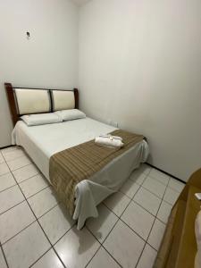 a bed sitting in a room with a tiled floor at Center 1 Hotel in Fortaleza