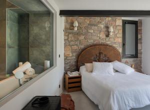 a bedroom with a bed and a stone wall at Auberge hiribarren in Biriatou