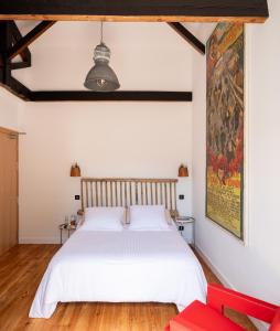 1 dormitorio con 1 cama blanca y 1 silla roja en Auberge hiribarren, en Biriatou