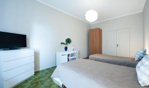 sypialnia z 2 łóżkami i telewizorem z płaskim ekranem w obiekcie La Casa di Merion w mieście Posatora