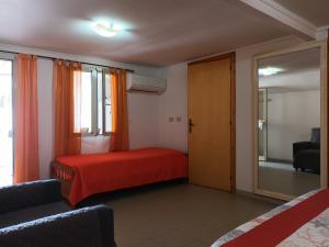 - une chambre avec un lit rouge et un miroir dans l'établissement Giardino Del Sole, à Tropea