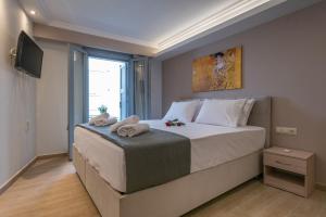 a bedroom with a large bed and a television at OLYMPIA ROOMS in Myrina