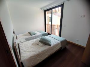 a bedroom with a bed with pillows on it at Casa João Eusébio 3 in Ponte de Lima +2 photos