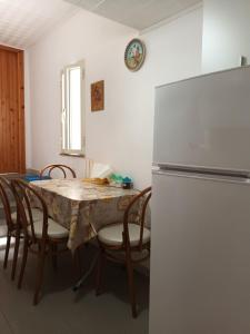 Il comprend une cuisine équipée d'une table, de chaises et d'un réfrigérateur. dans l'établissement Giardino Del Sole, à Tropea