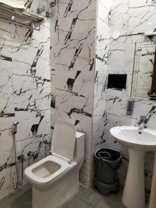 a bathroom with a white toilet and a sink at Anushangi Hotel in Hisār