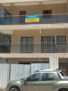 a green car parked in front of a building at Temporada Serrana in Guaramiranga