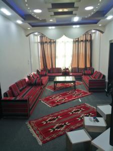 una sala de estar con sofás rojos y una mesa. en Petra paradise home en Wadi Musa