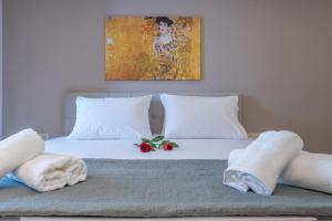 a bedroom with a bed with towels and a painting at OLYMPIA ROOMS in Myrina