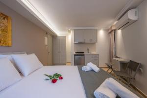 a bedroom with a large white bed with flowers on it at OLYMPIA ROOMS in Myrina