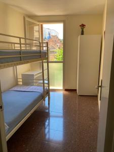 a room with two bunk beds and a refrigerator at Luminoso apartamento en Canet de Mar cercano a la playa y a Barcelona in Canet de Mar