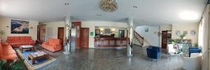 a large living room with orange furniture and a staircase at Hotel Con D´Arbon in A Lanzada