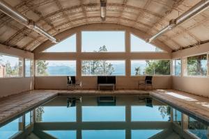 an indoor pool with chairs in a large room with windows at Basia Hotel & Sushi in San Carlos de Bariloche
