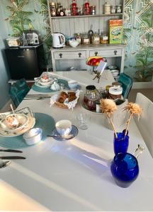 a kitchen counter with a blue vase with flowers in it at CreekSide Bed and Breakfast Faversham in Faversham