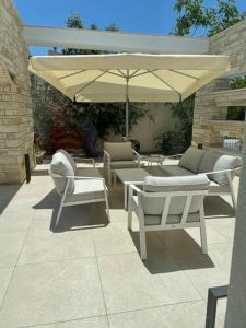 une terrasse avec des chaises, un parasol et une table dans l'établissement Paphos luxury contemporary villa, à Paphos