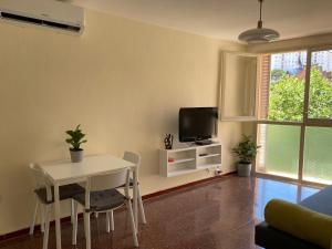 uma sala de estar com uma mesa branca e uma televisão em Luminoso apartamento en Canet de Mar cercano a la playa y a Barcelona em Canet de Mar