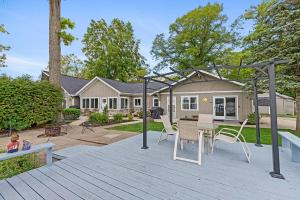 a patio with a table and chairs and a house at Waterfront Suite centrally located w/ private dock in Newaygo