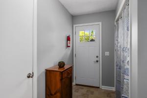 a hallway with a white door and a wooden table at Waterfront Suite centrally located w/ private dock in Newaygo