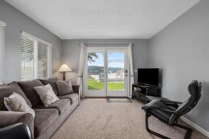 a living room with a couch and a chair and a television at Waterfront Suite centrally located w/ private dock in Newaygo