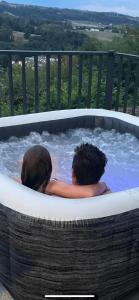 2 personas en un jacuzzi en una bañera de hidromasaje en Gîte Latsou Magnifique plain-pied avec terrasse, 