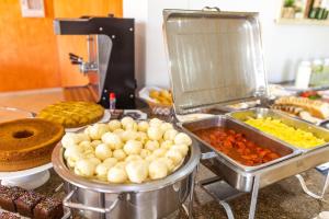 a buffet with many different types of food on a counter at Pousada Recanto das Flores in Governador Celso Ramos