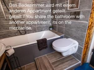 La salle de bains est pourvue de toilettes blanches et d'une baignoire. dans l'établissement #213 LUX-Room - Zentrum Neuss - Nähe Düsseldorf Messe mit Netflix & Prime, à Neuss