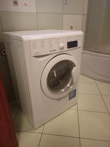 a white washing machine sitting in a bathroom at Apartament Komorniki in Komorniki