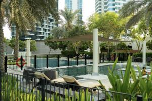 a pool with a table and chairs and an umbrella at Luxury 3 BR - Direct View to Burj Khalifa in Dubai