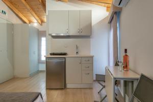 a kitchen with white cabinets and a table in a room at OLYMPIA ROOMS in Myrina +24 photos