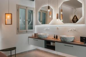 two sinks in a bathroom with a mirror at K suites ios in Ios Chora +49 photos