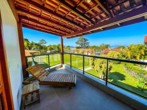 a balcony with a bench and a view at Pousada Recanto das Flores in Governador Celso Ramos
