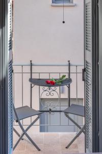 a table and two chairs on a balcony at OLYMPIA ROOMS in Myrina