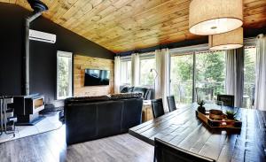 sala de estar con techo de madera y mesa de comedor en Condo 88 Chemin des Alpages by Les Chalets Alpins, en Stoneham