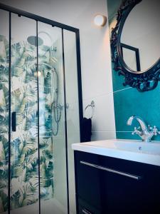 a bathroom with a shower and a sink and a mirror at Apartamenty Krasicki in Lidzbark Warmiński