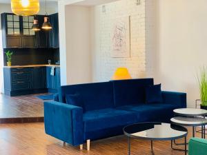 a living room with a blue couch and tables at Apartamenty Krasicki in Lidzbark Warmiński