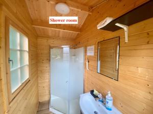 a bathroom with a sink and a shower room at Algonquin Madawaska Lodge Cottage Glamping Cabins in Madawaska