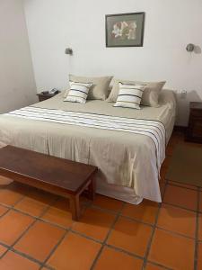 1 cama grande con 2 almohadas y mesa de madera en Hosteria Automovil Club Argentino Cachi en Cachí