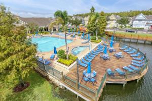 eine Luftaufnahme eines Pools mit Stühlen und einer Terrasse in der Unterkunft 4 Bedroom Townhouse in a Gated Resort! in Kissimmee