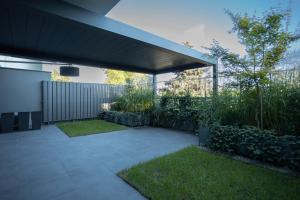 a patio with awning and grass in a yard at Apartament Zwirki in Toruń